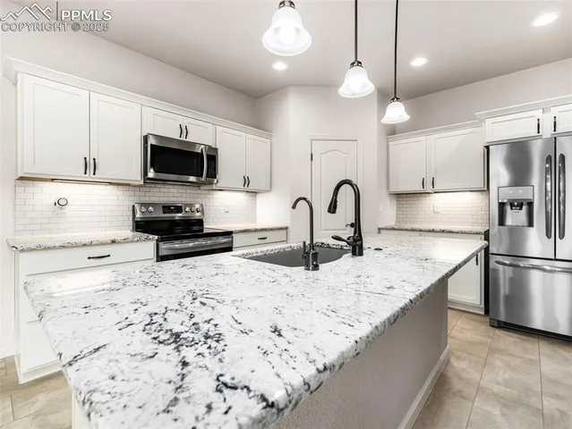 a large kitchen with granite countertop a stove and a sink