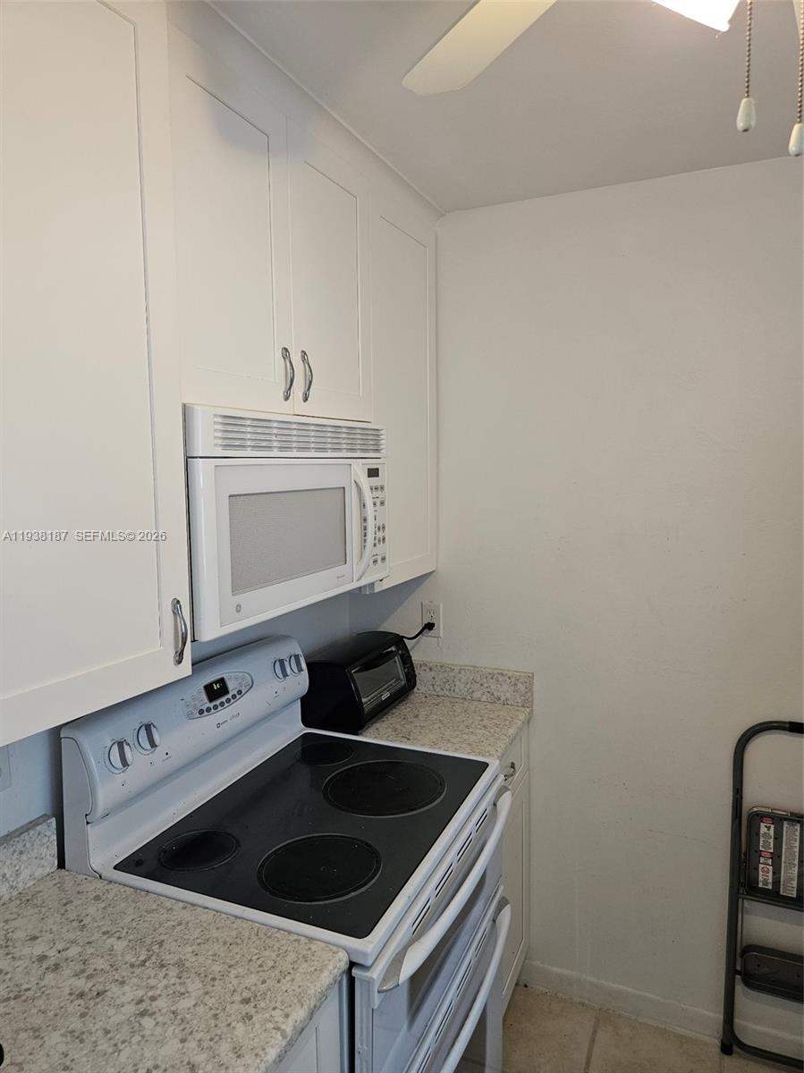 126 Citrus Road Northeast Lake Placid, FL 33852 - Photo 12 of 25 a kitchen with a stove and a white cabinet