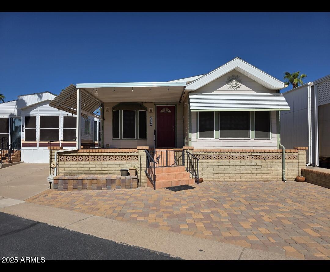 2359 East Pima Avenue Apache Junction, AZ 85119 - Photo 1 of 24 a view of a house with large windows and a small yard