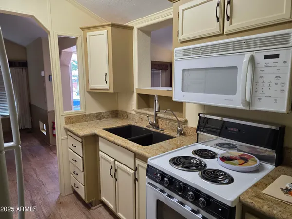 a kitchen with a refrigerator sink stove and cabinets