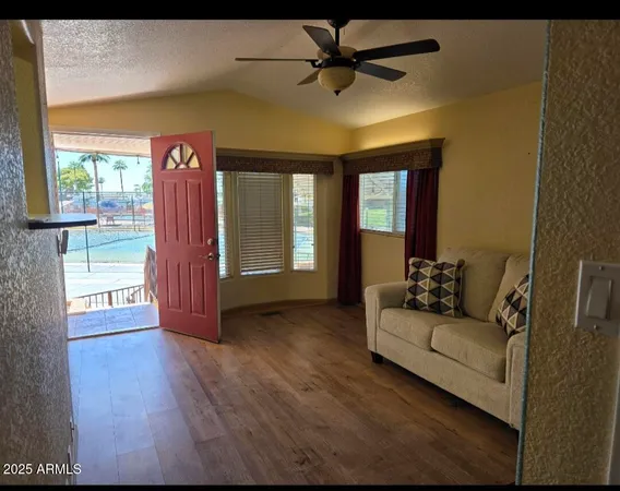 a view of a livingroom with wooden floor and ceiling fan