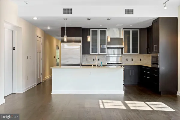 a kitchen with kitchen island stainless steel appliances a sink and cabinets