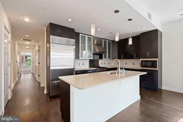 a large kitchen with stainless steel appliances a large counter top