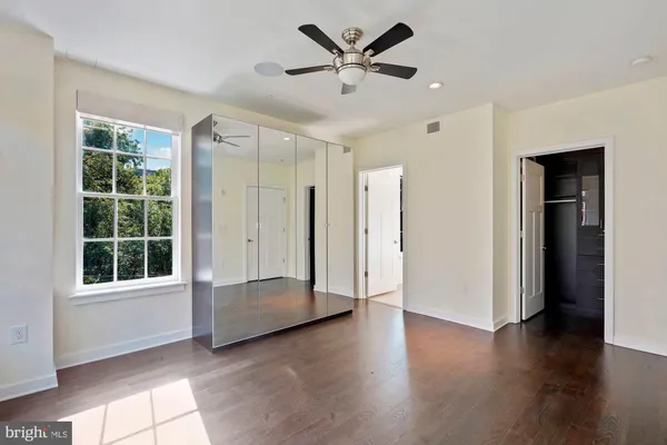 a view of room with window ceiling fan and hardwood floor