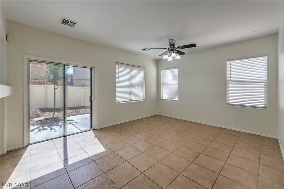 10939 Paradise Road Henderson, NV 89052 - Photo 13 of 36 A well-lit interior with tile flooring opens to an outdoor space through sliding glass doors.