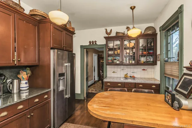 a room with stainless steel appliances granite countertop a sink refrigerator and cabinets