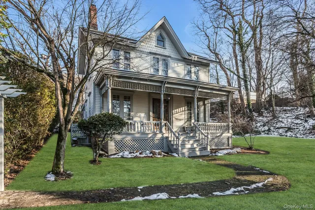 a front view of house with a garden and trees