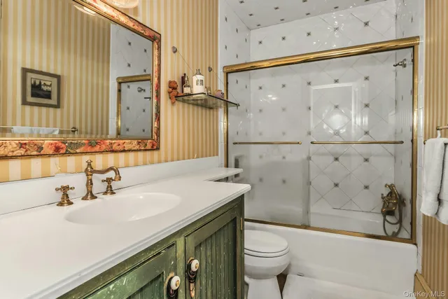 a bathroom with a sink a toilet and a large mirror