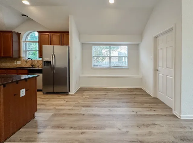 a kitchen with granite countertop a refrigerator and a sink