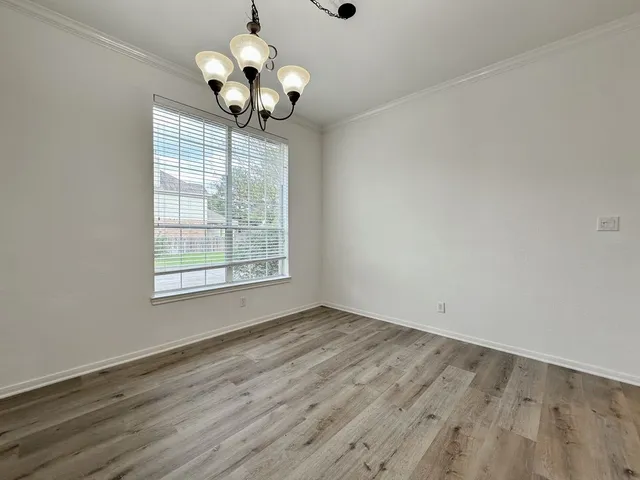 a view of a room with wooden floor and chandelier