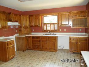 28 Spring Lane Clyde, NC 28721 - Photo 4 of 20 a kitchen with a sink stove and cabinets