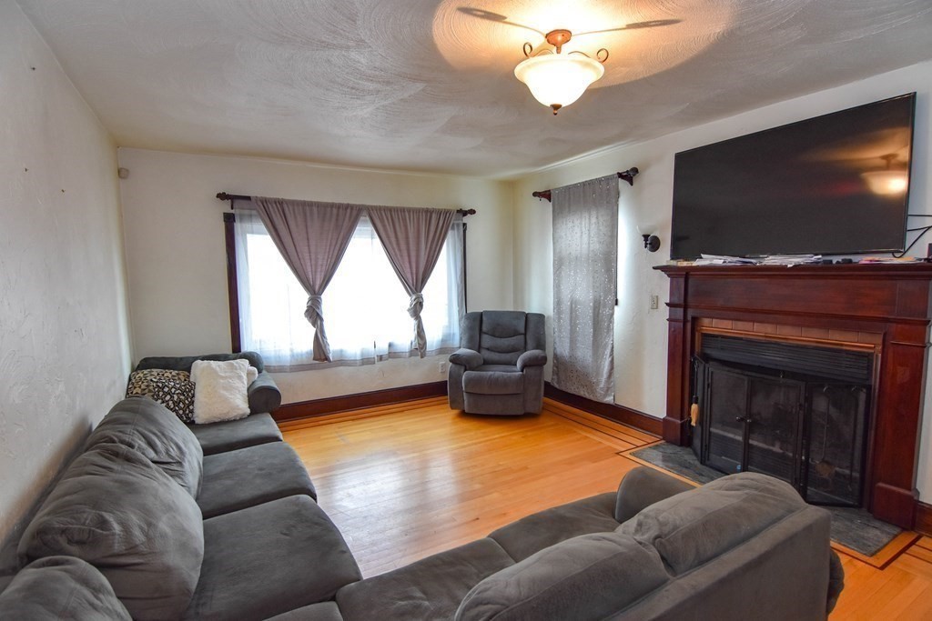 16 Putnam Road Somerville, MA 02145 - Photo 14 of 23 a living room with furniture a flat screen tv and a fireplace