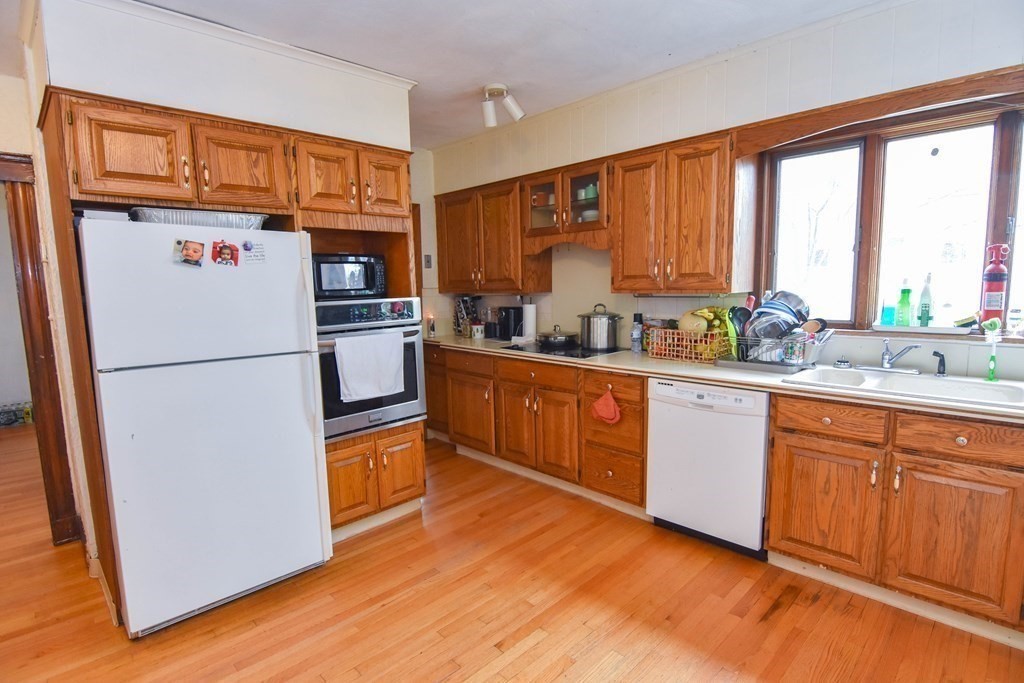 16 Putnam Road Somerville, MA 02145 - Photo 16 of 23 a kitchen with stainless steel appliances granite countertop a refrigerator a sink dishwasher a stove with wooden cabinets and wooden floor