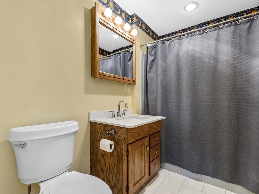 16 Putnam Road Somerville, MA 02145 - Photo 8 of 23 a bathroom with a sink a toilet a mirror and shower curtain
