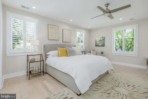 a bathroom with a granite countertop sink a toilet a mirror a vanity a bathtub and shower