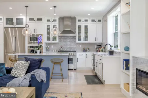 a kitchen with stainless steel appliances granite countertop a stove a refrigerator a oven a sink with a dining table and chairs