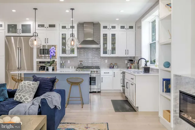 a kitchen with stainless steel appliances granite countertop a stove a refrigerator a oven a sink with a dining table and chairs