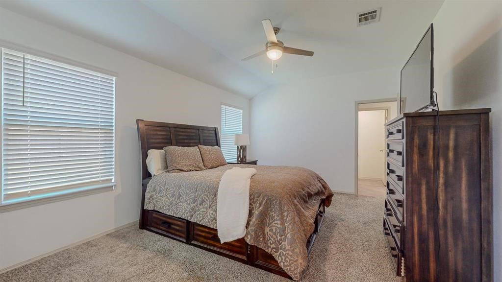 6710 Riplee Street Beaumont, TX 77708 - Photo 11 of 27 a bedroom with a bed and a chandelier