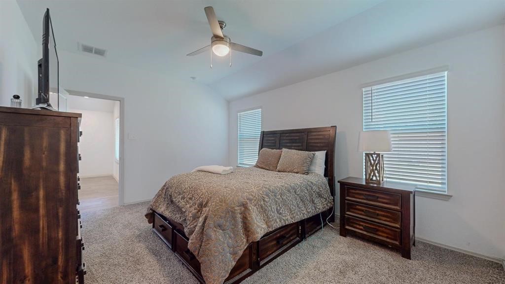 6710 Riplee Street Beaumont, TX 77708 - Photo 13 of 27 a bedroom with a bed and a chandelier