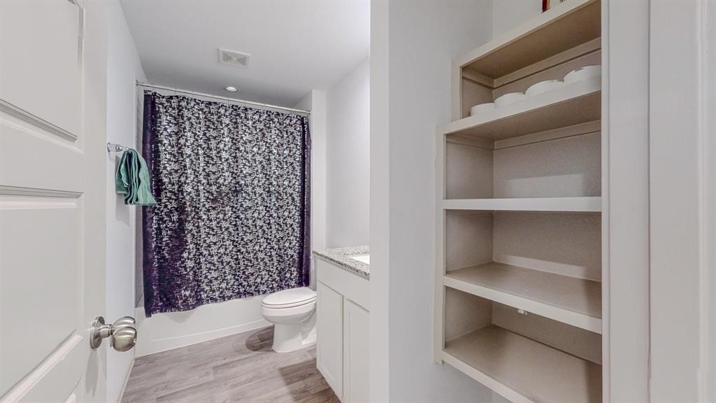 6710 Riplee Street Beaumont, TX 77708 - Photo 22 of 27 a bathroom with a toilet and a shower curtain