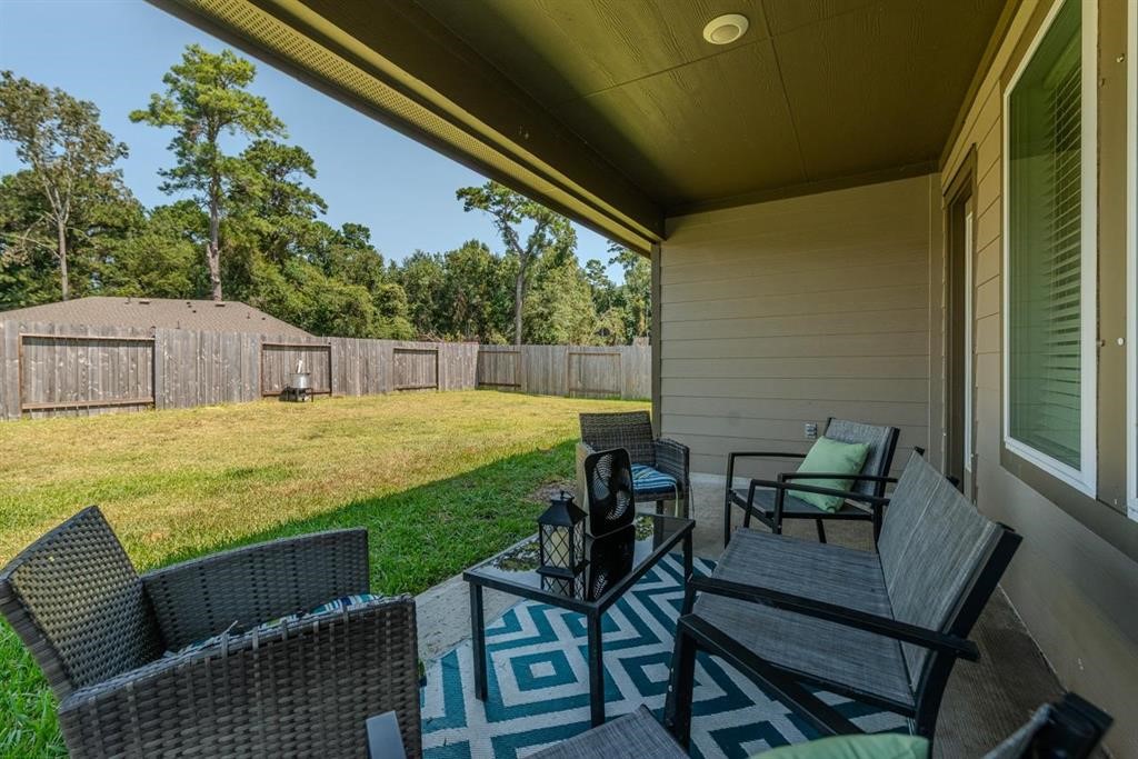 6710 Riplee Street Beaumont, TX 77708 - Photo 24 of 27 a view of a patio with table and chairs and potted plants with wooden floor and fence