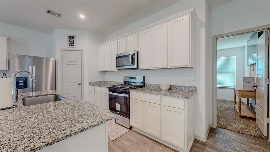 6710 Riplee Street Beaumont, TX 77708 - Photo 7 of 27 a kitchen with granite countertop a sink stove and refrigerator