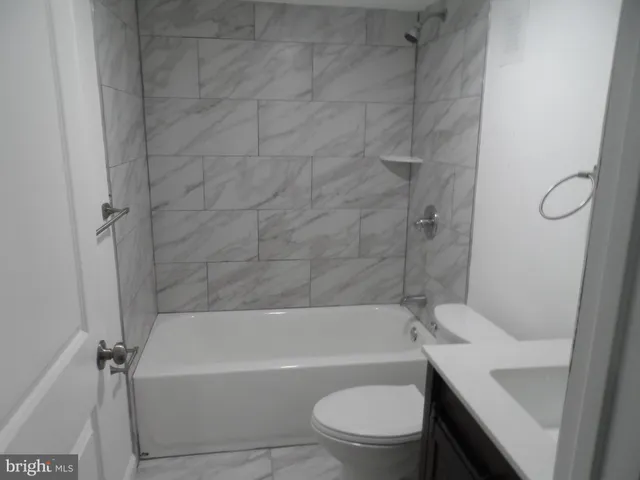 a bathroom with a toilet and a bath tub