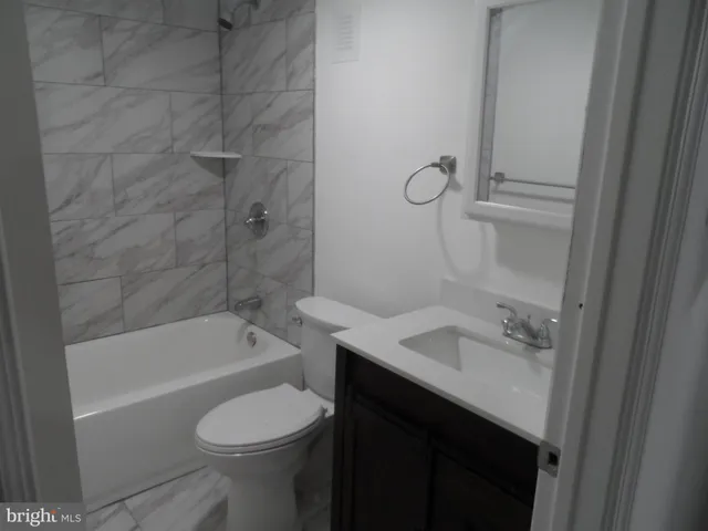 a bathroom with a sink toilet vanity and bathtub