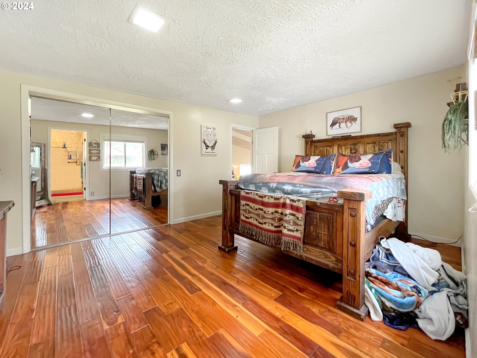 17676 Gardner Ridge Road Brookings, OR 97415 - Photo 22 of 42 a bedroom with a bed and wooden floor