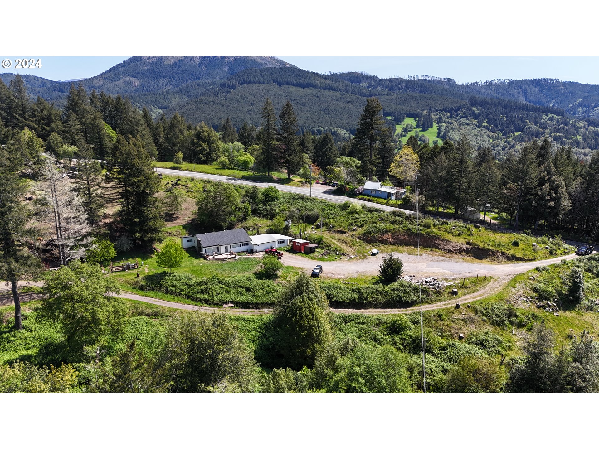 17676 Gardner Ridge Road Brookings, OR 97415 - Photo 40 of 42 a view of a lush green hillside and a houses
