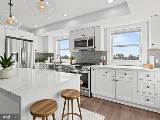 a kitchen with granite countertop a sink cabinets and wooden floor