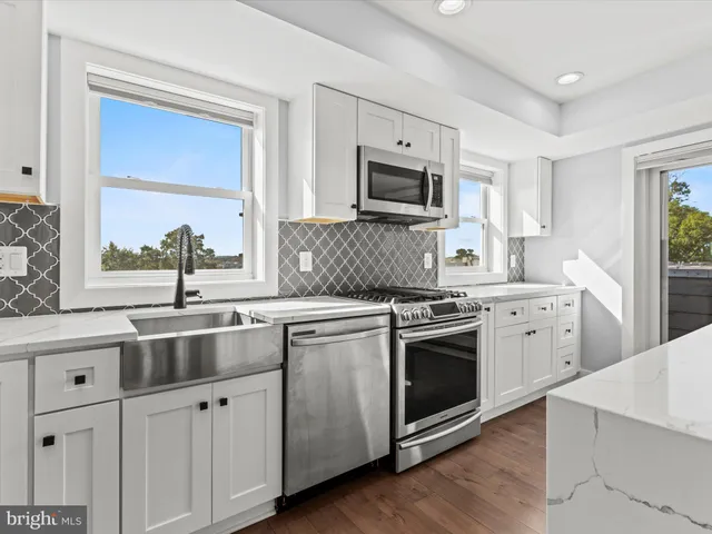a kitchen with appliances a sink and cabinets