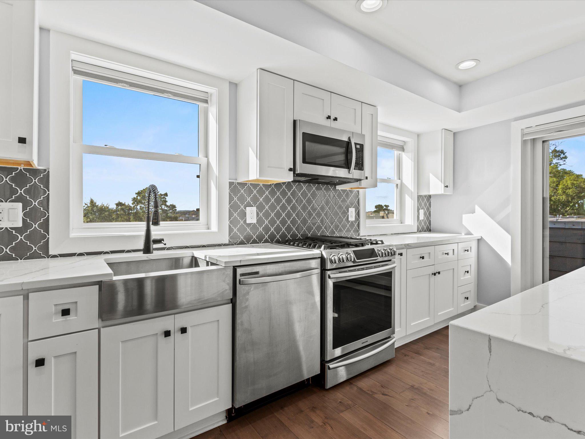 1267 Penn Street Northeast, Unit B Washington, DC 20002 - Photo 6 of 18 a kitchen with appliances a sink and cabinets