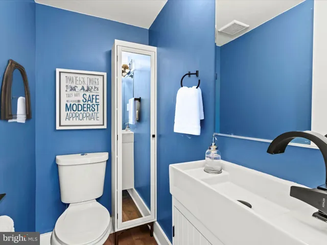 a bathroom with a toilet a sink and mirror