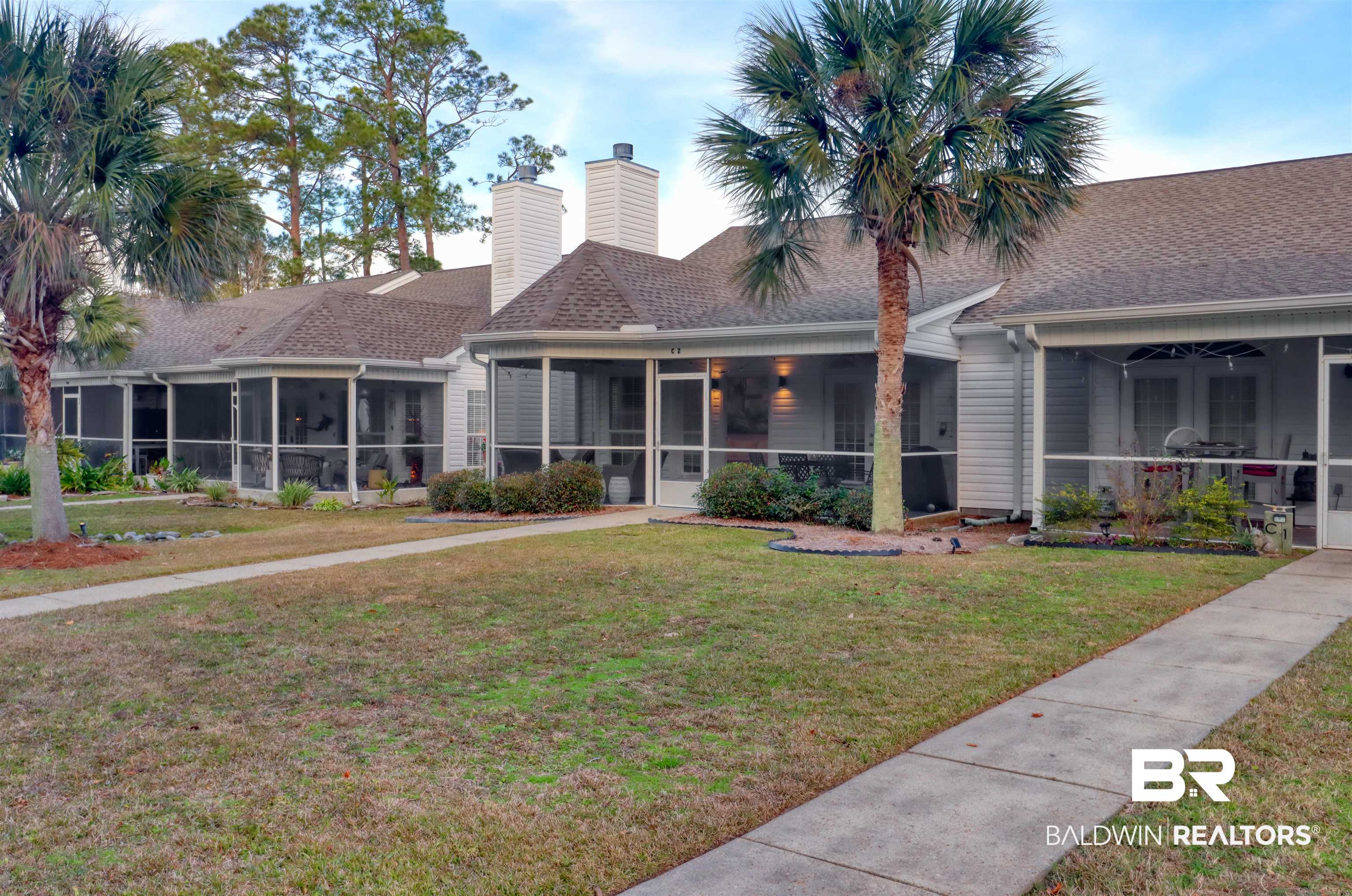 26063 Canal Road, Unit C2 Orange Beach, AL 36561 - Photo 1 of 30 View of front facade featuring a sunroom, a front lawn, and a shingled roof
