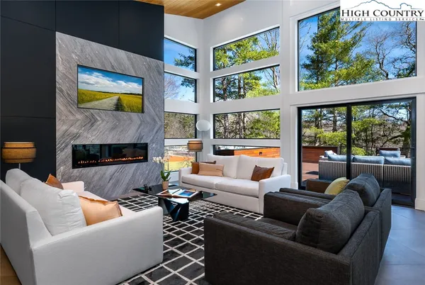 a living room with fireplace furniture and a large window