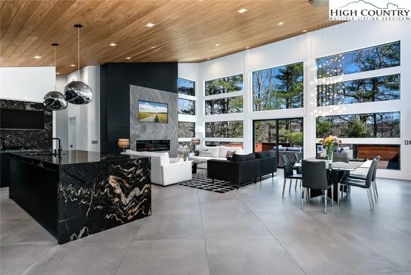 a living room with furniture a floor to ceiling window and flat screen tv