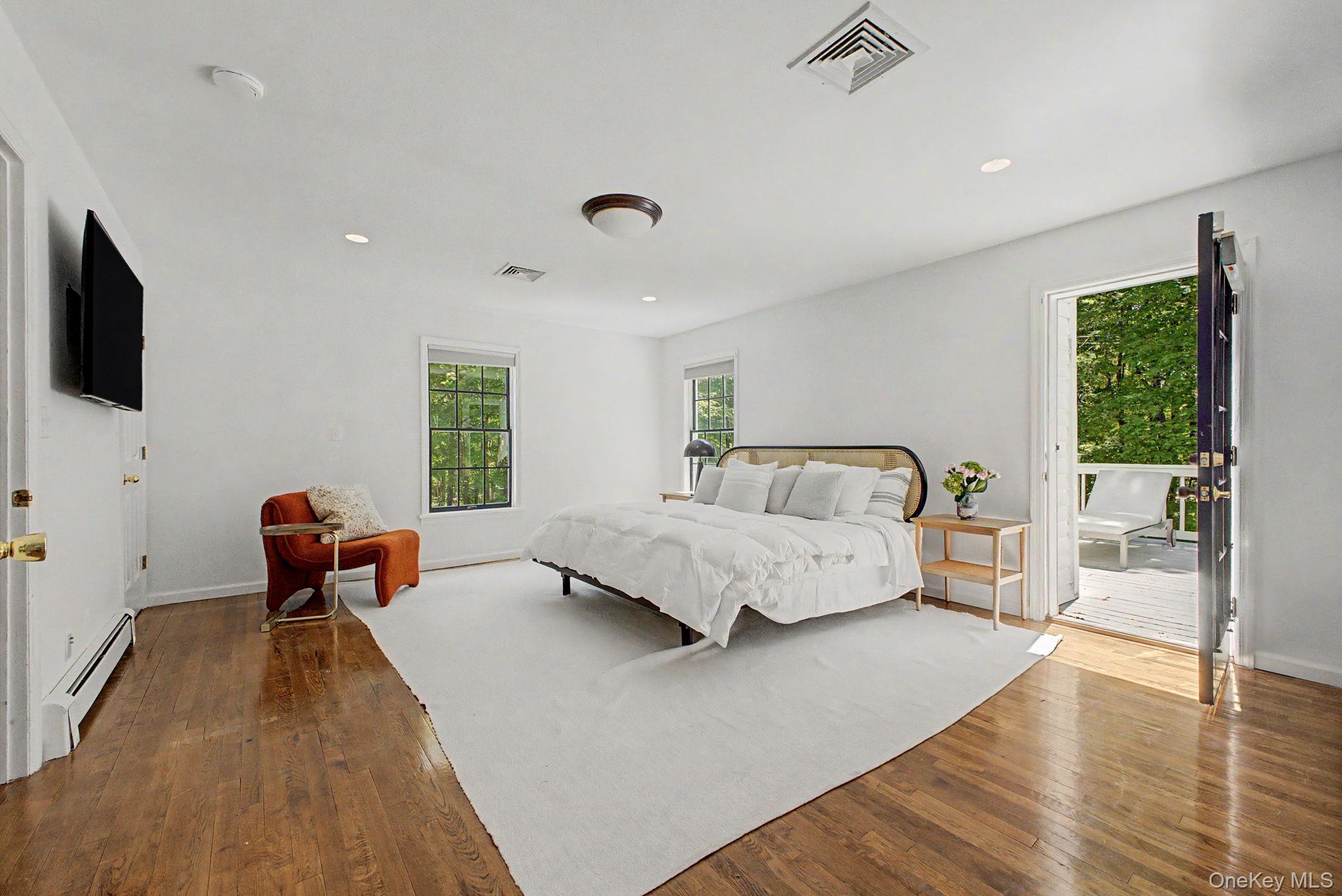 240 Eastwoods Road Pound Ridge, NY 10576 - Photo 32 of 46 a spacious bedroom with a bed and a flat screen tv