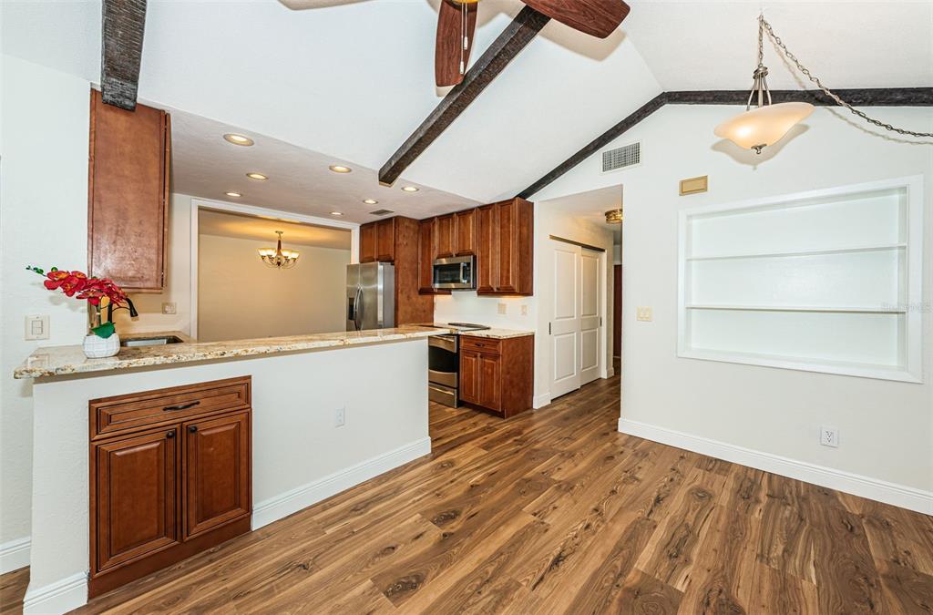 4723 114th Street North Madeira Beach, FL 33708 - Photo 12 of 41 a kitchen with wooden cabinets and white appliances