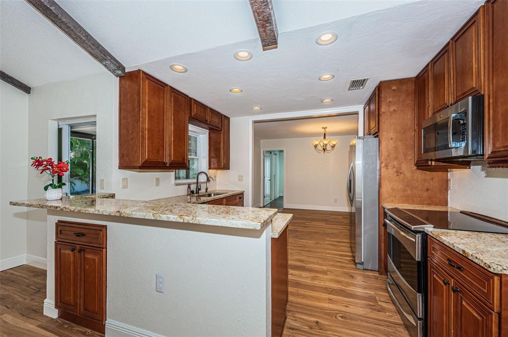 4723 114th Street North Madeira Beach, FL 33708 - Photo 17 of 41 a kitchen with stainless steel appliances granite countertop a sink stove and refrigerator