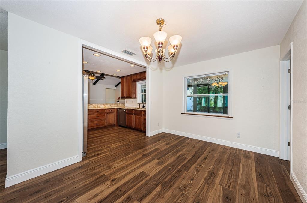 4723 114th Street North Madeira Beach, FL 33708 - Photo 18 of 41 a view of a room with wooden floor and chandelier