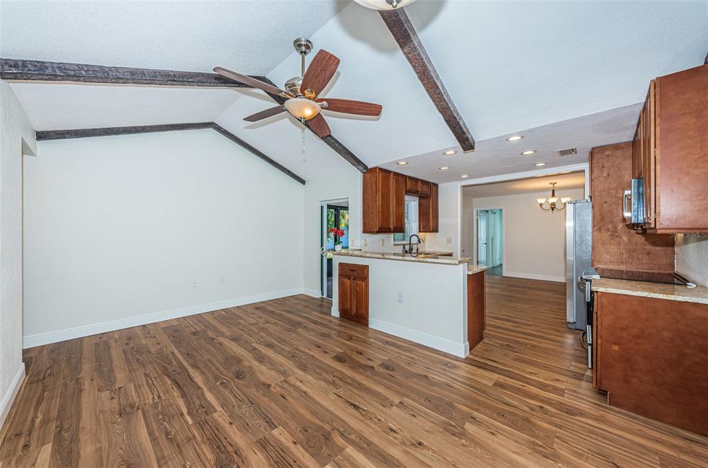 4723 114th Street North Madeira Beach, FL 33708 - Photo 20 of 41 a view of kitchen and empty room with wooden floor