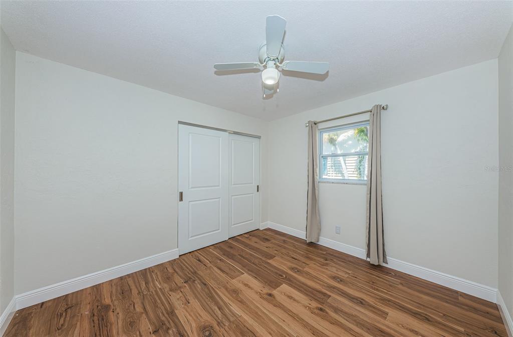 4723 114th Street North Madeira Beach, FL 33708 - Photo 29 of 41 a view of a livingroom with wooden floor and a ceiling fan