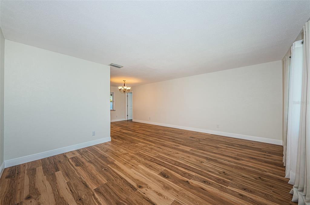 4723 114th Street North Madeira Beach, FL 33708 - Photo 5 of 41 a view of an empty room with wooden floor