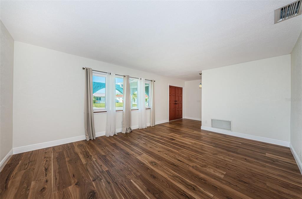 4723 114th Street North Madeira Beach, FL 33708 - Photo 8 of 41 a view of an empty room with wooden floor and a window