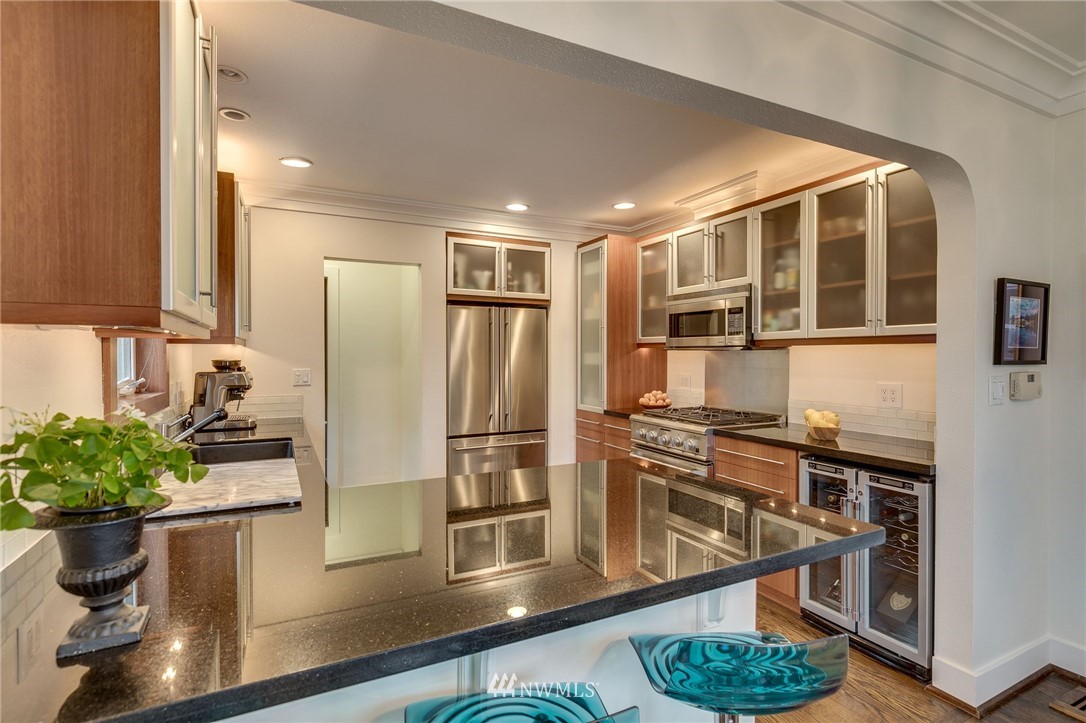 2565 35th Avenue West Seattle, WA 98199 - Photo 9 of 36 a kitchen with stainless steel appliances granite countertop a refrigerator a stove and a wooden floors