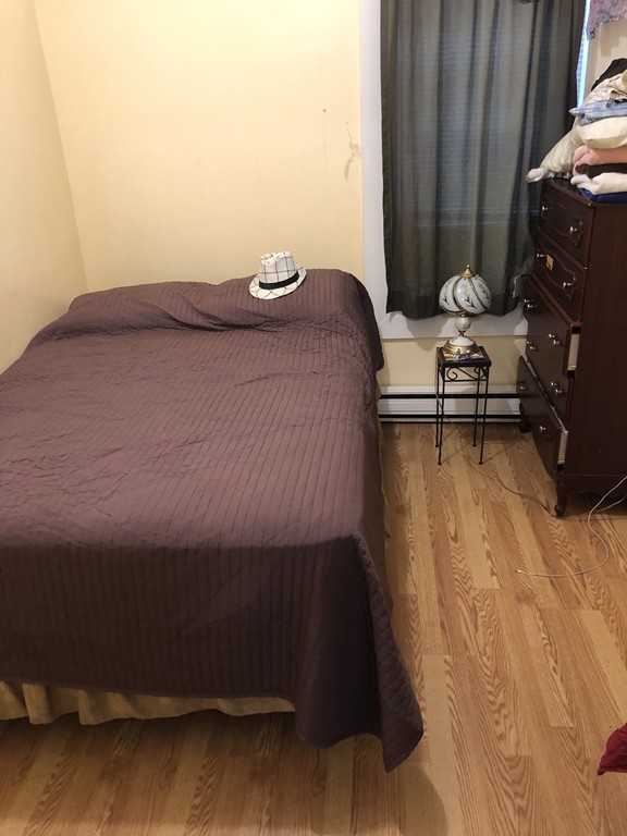 16 Prospect Court Lawrence, MA 01841 - Photo 12 of 14 a bedroom with a bed and a chair