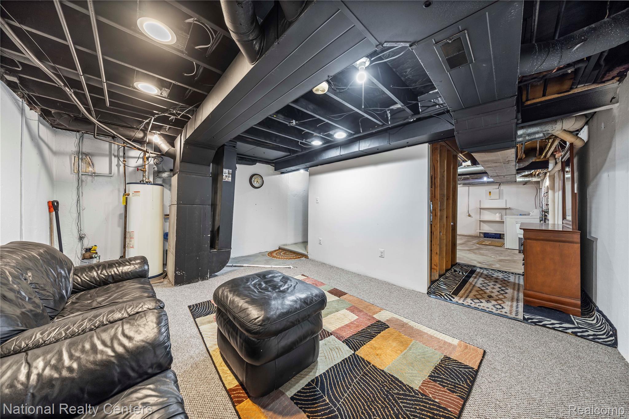 5274 East 14 Mile Road Warren, MI 48092 - Photo 24 of 31 Exposed black ceiling joists and ductwork, recessed lighting, carpeted flooring, and a water heater