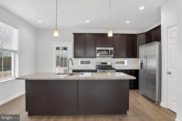 a kitchen with kitchen island a sink stainless steel appliances and cabinets