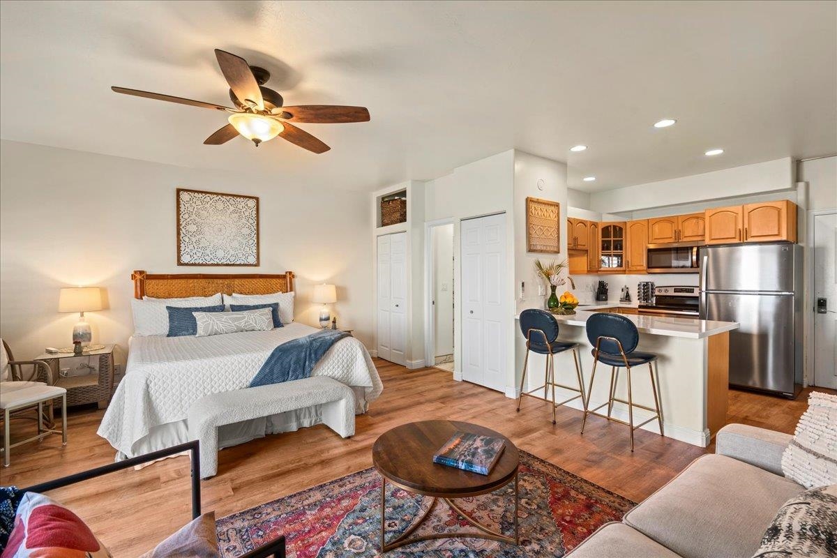 4435 Lower Honoapiilani Road, Unit 103 Lahaina, HI 96761 - Photo 11 of 34 a living room with furniture kitchen view and a chandelier